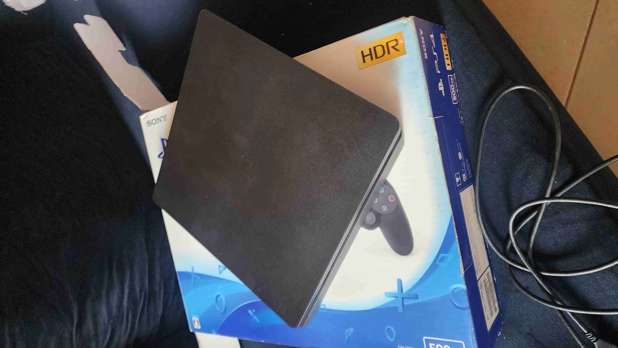 PlayStation 4 with FC26 disc and original Sony controller, ready for gaming.